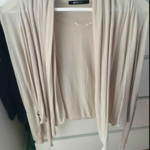  - Beige kofta från Gina. Jättefint fall och den går även att knyta runt kroppen snyggt. Kommer inte till användning av mig tyvärr. Knappt använd. Strl M