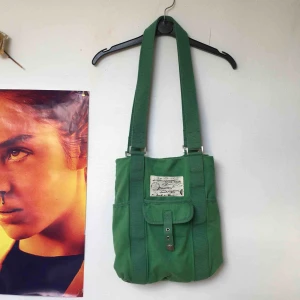  - Grön praktisk väska med många fack som rymmer mycket. 