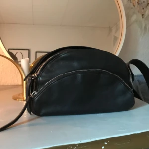  - Skitsnygg väska från &otherstories. Har kortat bandet hos en skomakare så bandets längd är 106 cm. Bredd 23 cm och höjd 15 cm. Perfekt liten väska. Äkta läder