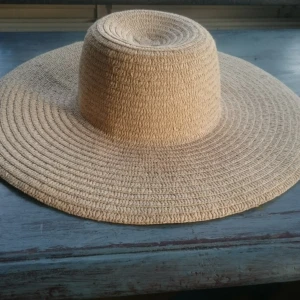  - Klassisk stor stråhatt av äkta strå! Ingen storlek angiven men jag har 55 cm i omkrets och skulle uppskatta att den funkar för 55-57 cm.  Inte använd många gånger så bandet på insidan är fräscht!