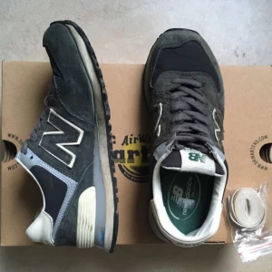  - New Balance 574  Använda ett fåtal gånger, väldigt fint skick!   Skosnörena som sitter i är ej original.  Vita originalsnören kommer med + de gråa som syns på bilden. 