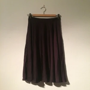  - Väldigt fin lila klockad kjol i glansigt tyg. Faller riktigt fint! Frakt tillkommer. 