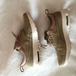  - Ett par snygga beiga Nile Air Max Thea skor som jag använt ett fåtal gånger pga för små. Så dem är i gott skick och rena på sulan! Sjukt snygga så känns så tråkigt att sälja.   PS. Ser ut som det är en rosa färg på kanterna på bilderna vilket det INTE är i verkligheten. De är samma beiga färg :)