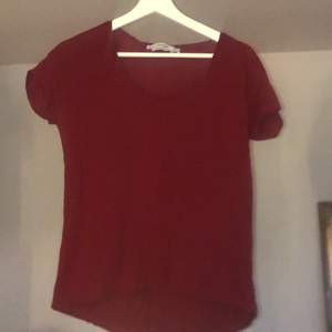 En röd t-Shirt, uringad, lite längre där bak