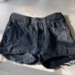 Levi’s shorts - Svarta jeansshorts från Levi’s modell 501. Passar mig som är storlek S och brukar ha storlek 26-27 i jeans. Levismärket sitter lite löst som det ska, syns på bilden. Köpare står för frakt. 