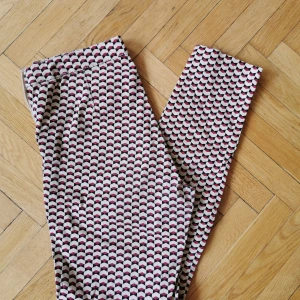 Mönstrade byxor från Hm - Tighta, mönstrade byxor från H&M. Dragkedja och knapp i sidan. Fejk-ficka bak. Snyggt mönster i rött, svart och ljusbeige.