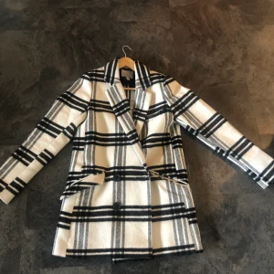 Trendig blazer-kappa  - Rutig kappa i blazermodell. Tyget är mjukt och kappa är i bra kvalitet då den endast är använd en vår. Frakt tillkommer, ca 100 kronor (kan diskutera) . Nypris: 811 kr.