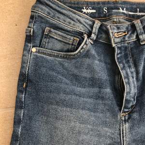 Mörkblå klassiska högmidjade jeans från BikBok. Fransdetaljer längst nee