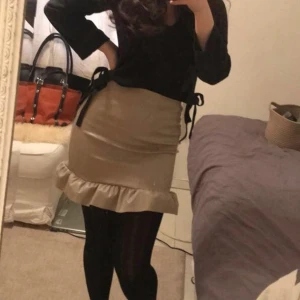 Kjol storlek 36 - Superfin kallbeige kjol någon slags lack/skinnimmitation. Använd 2 gånger tidigare. Bud 120