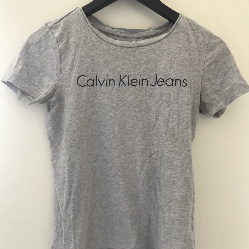 Grå T-shirt från Calvin Klein med svart logga fram. Fint skick! Storlek XS men hade kunnat passa S också 🌸. T-shirts.