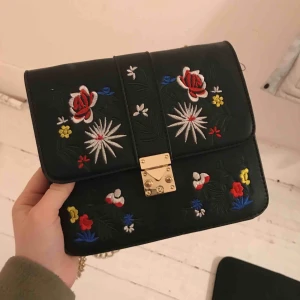  - Säljer en trendig väska i läderimitation med blommor på! Köpte den jätte-spontant och när jag väl kom hem så föll den mig inte i smaken längre, så det vill säga att den aldrig är använt!