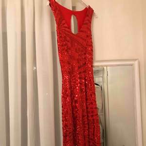 Lång röd klänning med öppet ben. 