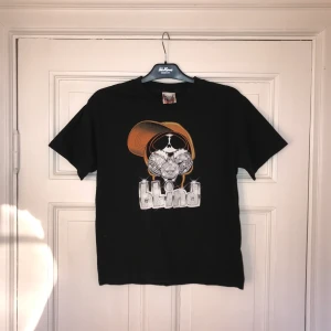 T-shirt från skatemärket Blind - En cool T-shirt från skatemärket Blind med riktigt coolt motiv. Storleken är youth L vilket motsvarar xs-s i vanlig storlek, hör av dig om du har frågor angående mått, passform eller om du undrar något annat. Tröjan har ett litet hål fram på.