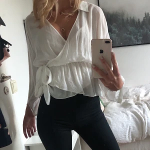 Vit topp - Supergullig, vit topp från Zara i som jag säljer då den tyvärr inte kommer till användning. Tröjan har ett justerbart knyte i sidan. Storlek XS men passar även S.