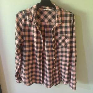Rosa och svart långärmad skjorta - Säljer denna skjorta eftersom jag har bytt stil. Tycker dock att den är både otroligt skön och fin. Går att styla knäppt, över T-shirt/linne eller knuten. Ganska väl använd men den är ändå i väldigt fint skick. Funkar Xs-M🥰 