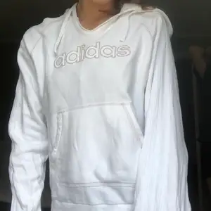 En vit, unik, vintage Adidas hoodie i super skick! Trycket är i korsstygn, har magficka och luva, mjuk insida, ränder i vitt pryder ärmarna. Köpt second hand, äkta vara🤩