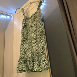 En somrig och blommig grön och vit klänning i stl S