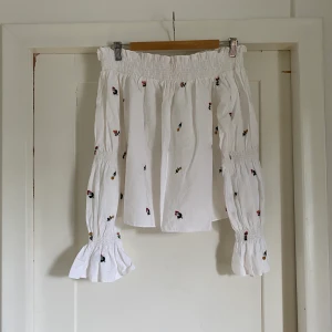 Topp blommig vit Zara - Topp från Zara blommig och vit, med bara axlar, bardotmodell. 