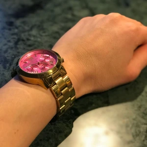  - Missa inte chansen! Nu är det dags för mig att gå vidare och låta någon annan få äran att bära denna fina guldklocka från Michael kors. Som sagt, den är guldig och med rosa urtavla. Väldigt tjejig och också väldigt elegant.  Nytt batteri krävs. Annars är den inprincip som ny i utseende. Jag har liten handled så den är ganska ”smal” runtom men det går att justera. Om du tror att detta är klockan för dig, så är du mer än välkommen att höra av dig.  