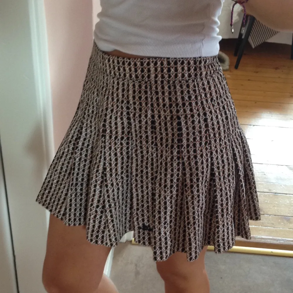Vintage-kjol i brun-svart-vittmönster. Knappen där bak är borta men dragkedjan fungerar. Lite 