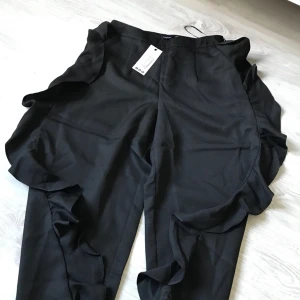  - Helt nya kavajbyxor med volanger på sidorna. Prislapp kvar från Bohoo. Passar S med. Hämtas i Gbg/Mölndal annars står köparen för frakt. 