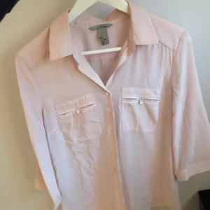  - Ljusrosa skjorta/blus i tunt material, sparsamt använd. Betalning sker via swish och köparen står för eventuell frakt🌸