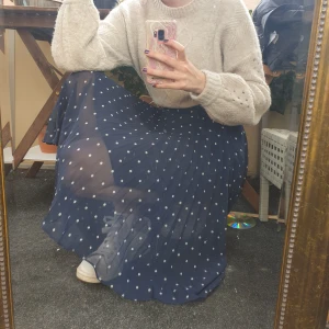 Pressad kjol - Marinblå, pressad kjol med vita prickar. Den är lätt att styla och fett snygg. Har använt den mycket, den är lite sliten (syns på bilderna), därav det låga priset! Slitningarna märks inte när man har den på sig.