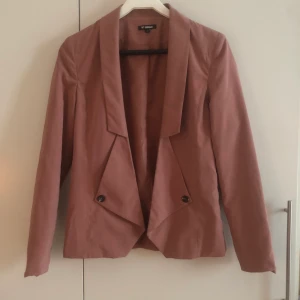 Kavaj - Gammalrosa kavaj från Minimum. Endast använd för bilder, är tyvärr lite för liten på mig. Den är inte gjord för att knäppas.  Tyget känns väldigt mjukt, typ som fejk tunn mocka. Extraknappar finns i kavajen, inga fickor. Köpt för 800.