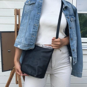 svart läderväska  - snygg och stilren väska i svart äkta läder, justerbar axelband, fler fack innuti inklusive en korthållare. använd men alla dragkedjor fungerar som de ska!