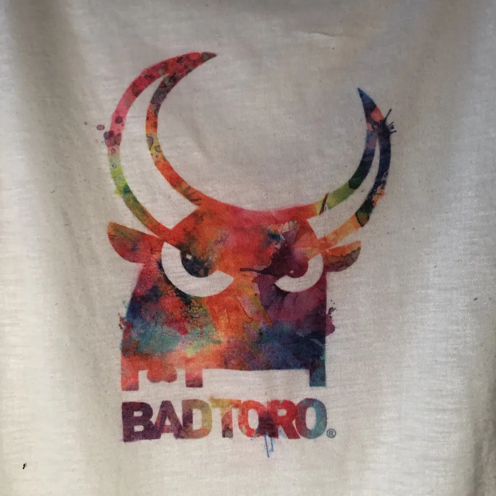 Vit t-shirt med tryck från badtoro. Genomskinlig. Storlek xs. T-shirts.