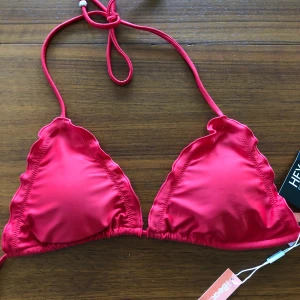 Röd bikiniöverdel från Nelly - Helt oanvänd bikiniöverdel med prislapp kvar! Aldrig använd. Storlek L men skulle mer säga M