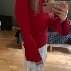 Stickad röd tröja - En jätte fin röd stickad tröja, som går ut i armarna.