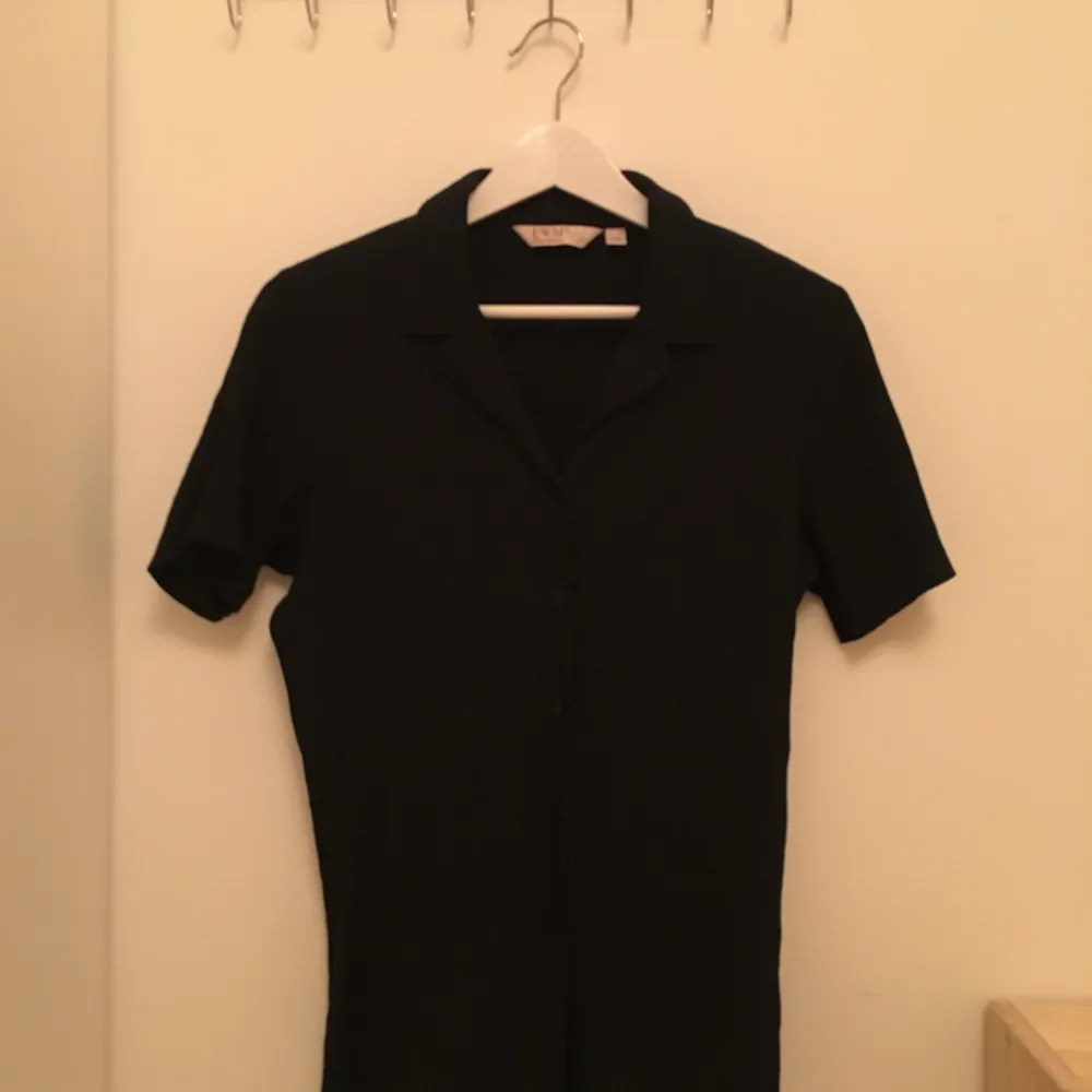 Superfin svart kortärmad skjorta/blus med veckad struktur på tyget. Polyester-/bomullsblandning och i fint skick, köpt second hand. Storlek 14, men uppskattar till en S. . Blusar.