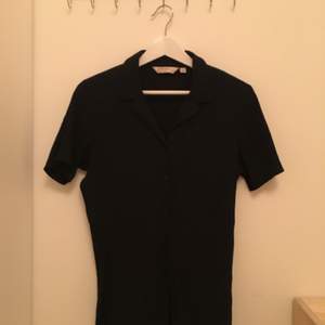Superfin svart kortärmad skjorta/blus med veckad struktur på tyget. Polyester-/bomullsblandning och i fint skick, köpt second hand. Storlek 14, men uppskattar till en S. 