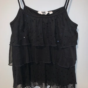 Linne - Ett svart linne med tre lager varav två har svarta paljetter. Det är i hyfsat skick, har ett litet hål (se bild) i nedre höger sida. Banden är väldigt långa. Det står 158/164 men jag som är en S passar den bra på☺️ OBS!! Köparen står för frakten!!💕