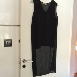  - Meshtop som är lång baktill, svart. Fejk-ficka fram. Knappar hela vägen upp.