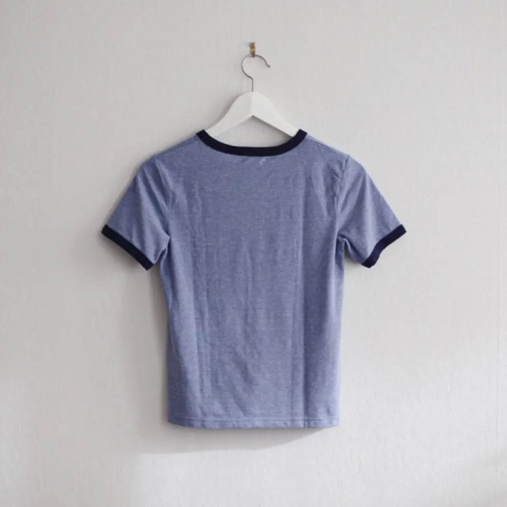 Blå ”Ringer” t-shirt från Cooperative by Urban Outfitters, lite kortare modell. 60% polyester, 28% bomull, 12% viskos. . T-shirts.