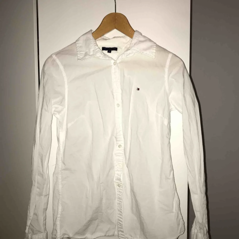 Aldrig använd vit skjorta från Tommy Hilfiger. Både väldigt snygg att ha under tröjor som sticker fram eller bara bära den.. Skjortor.