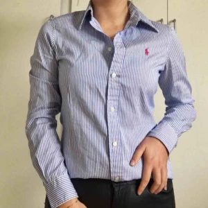  - Klarblå, vit randig Ralph Lauren skjorta. Använd någon enstaka gång och därför i mycket bra skick! 