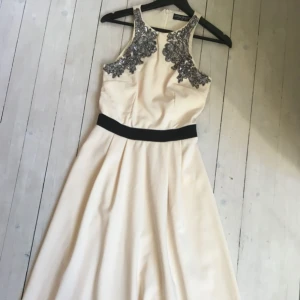  - Midi lång klänning från Little Mistress (Asos) i krämvit med silver och svarta detaljer 