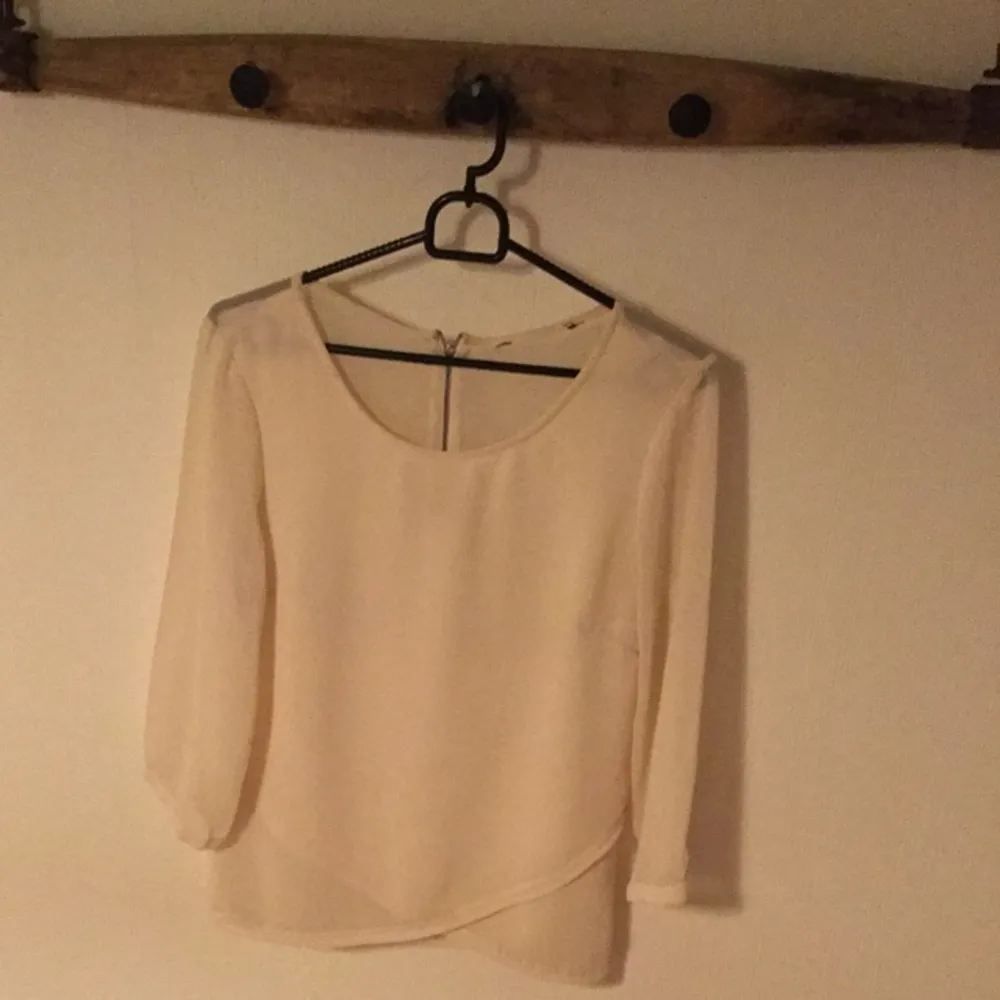 Cremefärgad bluse med transparent rygg
St S
Färg: Créme
Skick: inga synliga fel. Blusar.
