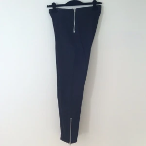 Svarta jeans med hög midja och snygga sömmar. Dragkedja i sidan och vid anklar. - Svarta jeans med hög midja och snygga sömmar. Dragkedja i sidan och vid anklar.