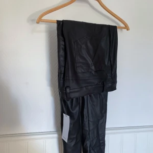 Skinnbyxor  - Oanvända skinnbyxor i fejkkläder! Jag köpte dem på rea på MANGO men har aldrig använt dem. Är i i L, jag har storlek 30 på jeans och dem passar mig bra! Om fler är intresserade blir det budgivning. Står ej för frakt! 