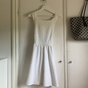 En jättefin vit kläning i från bikbok, i storlek M. Axelbanden på klänningen går som ett kryss i ryggen (se bild). Finns även fickor i sidorna