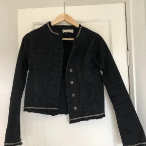 Svart jeansjacka  - Svart kort jeansjacka med silver detaljer 