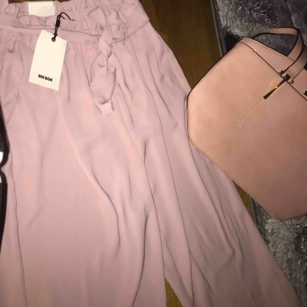 Ett par helt nya finbyxor av Bikbok i färgen babyrosa/ljusrosa i storlek L. Inte använt dem pga att dem är för långa på mig.  Prislappen finns kvar, vanliga priset: 350kr. Jeans & Byxor.