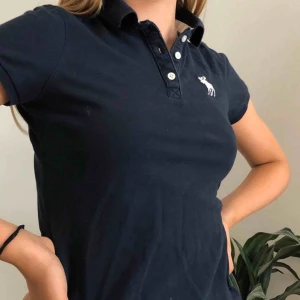  - Fin marinblå/vit Abercrombie & Fitch piké. Strl: S  Startpris: 39 kr