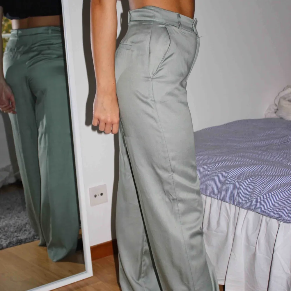 Riktigt snygga ljusgröna och glansiga byxor! Högmidjade och relativt långa i benen, modellen är 170cm! Köparen står för frakten🥰. Jeans & Byxor.