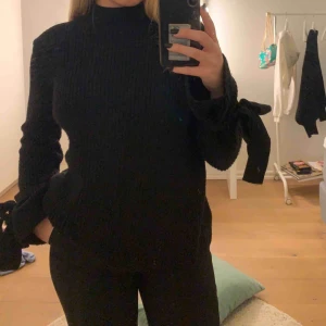  - Svart stickad tröja med knytning i armarna, går till höften ungefär. Sällan använd. Köparen står för frakt🥰