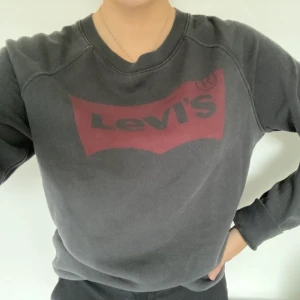 Levis tröja  - En svart tröja från Levis, har ett rött märke på bröstet. Är i storlek S, men passade mig som är 163 cm, som man ser på bild ett så stoppar jag in den. Har använt ca 5 gånger. 